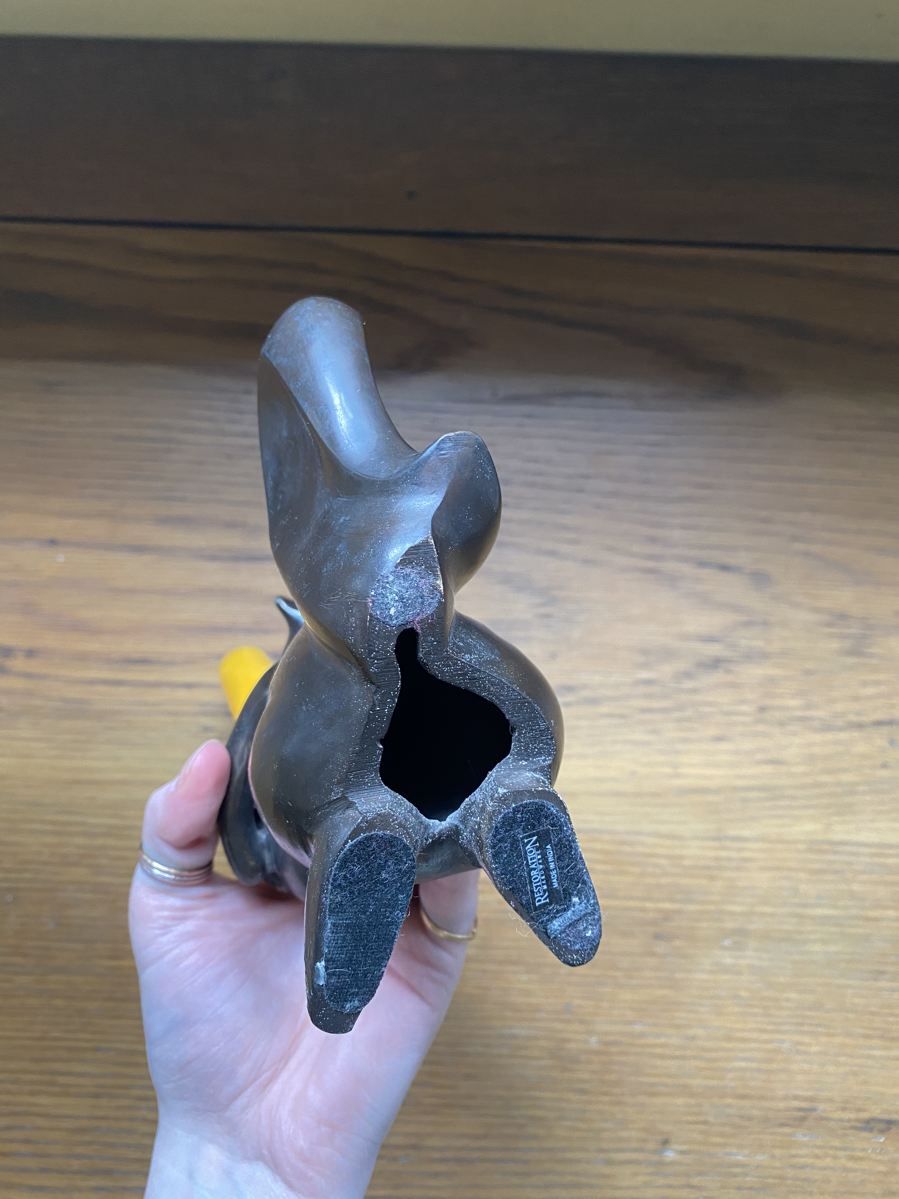 the bottom of the squirrel, the feet and body are flat for a steady base and hollowed out. the squirrel is from restoration hardware, evident from the sticker still on the bottom of the foot